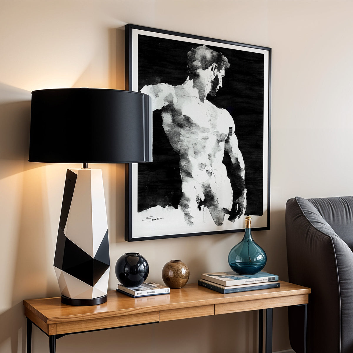 Black and white ink and watercolor male figure art print by Brenden Sanborn framed above a wood console with a geometric lamp