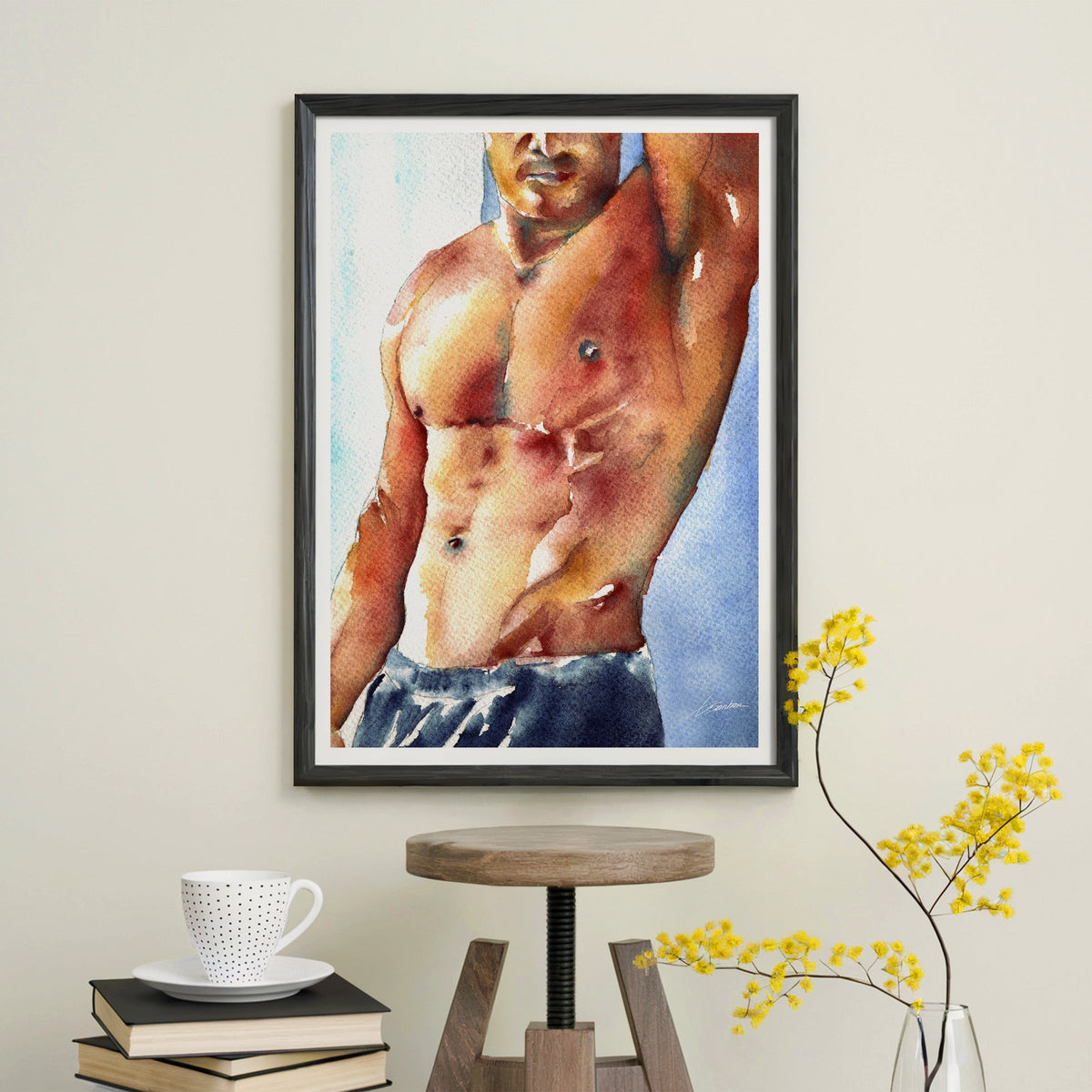 Male torso watercolor art print in a black frame above a wooden stool, Built collection by Brenden Sanborn