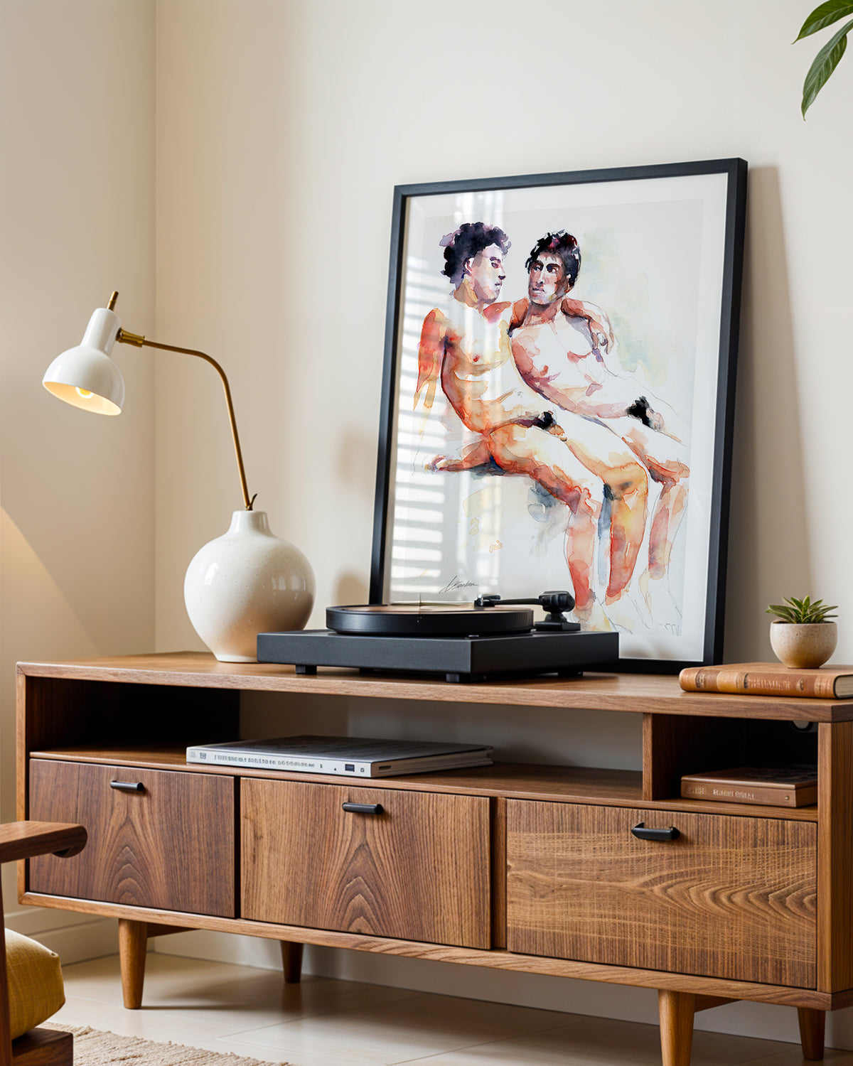Heavenly Moment art print in a black frame leaning on a walnut sideboard beside a record player