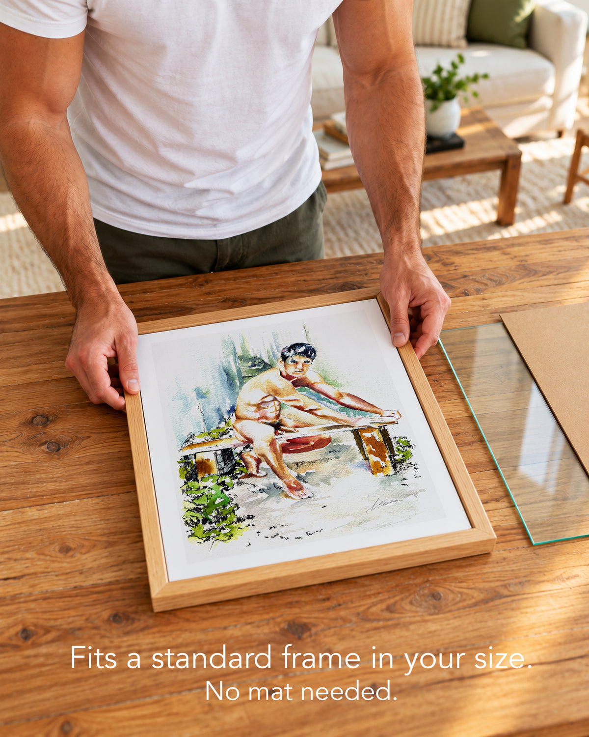 A man placing the Garden Bench paper art print with a white border into a standard wood frame, no mat needed