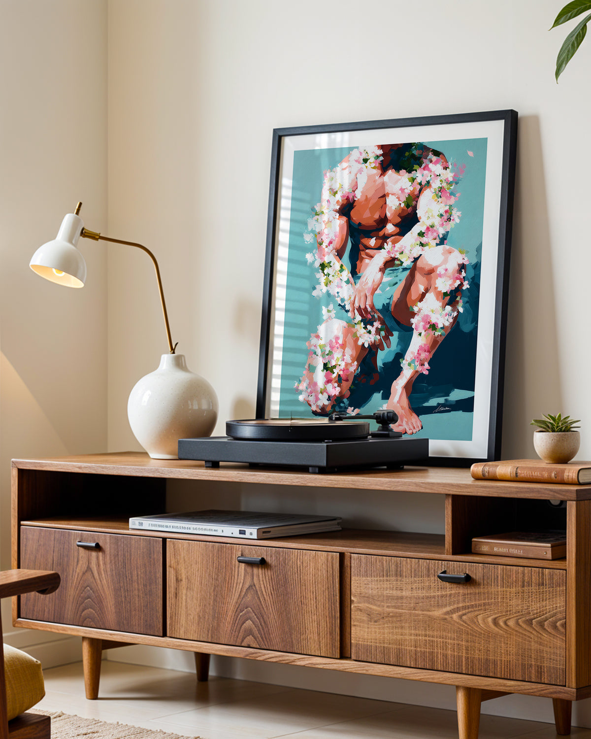 Low Bloom art print in a black frame leaning on a walnut sideboard beside a record player
