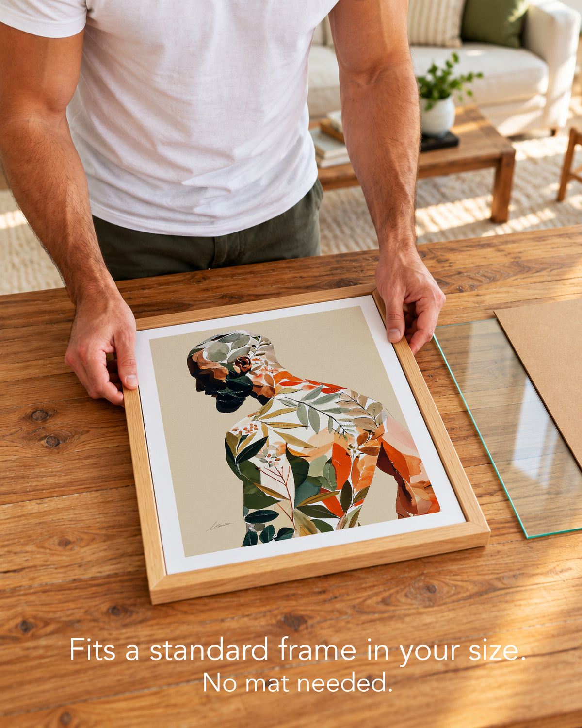 A man placing the Turning Leaf paper art print with a white border into a standard wood frame, no mat needed
