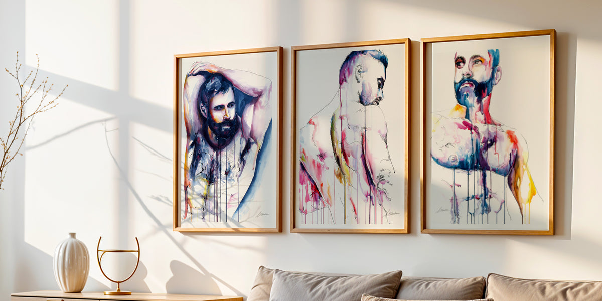Three Drip watercolor male figure art prints by Brenden Sanborn in light wood frames above a sofa in a sunlit living room