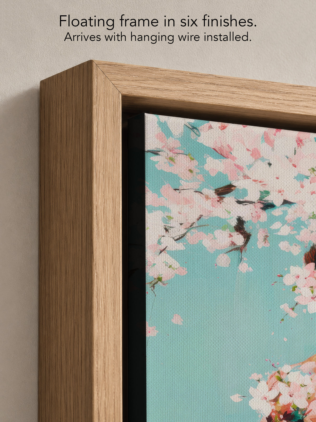 Close up corner of Falling Pink in a natural oak floating frame, with black canvas edges and hanging wire installed