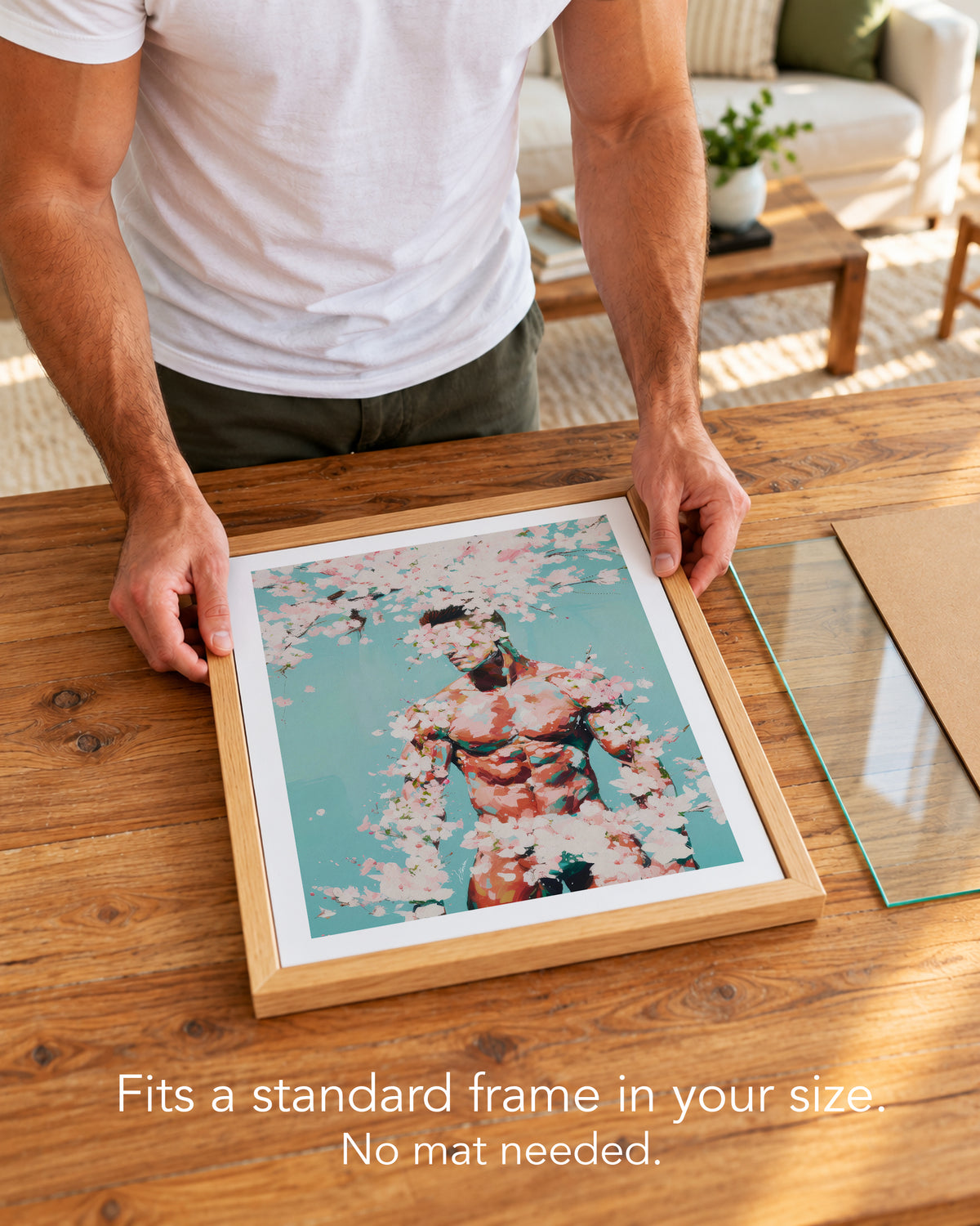 A man placing the Falling Pink paper art print with a white border into a standard wood frame, no mat needed