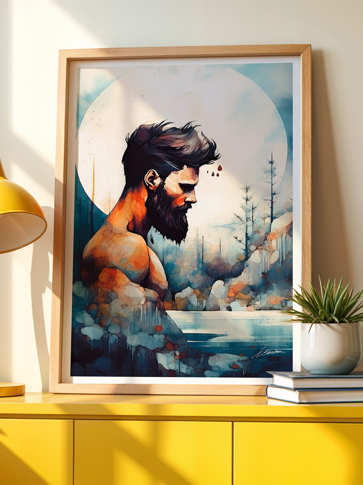 Framed print by Brenden Sanborn of a bearded man against a forest and a pale moon, in a light wood frame on a yellow sideboard