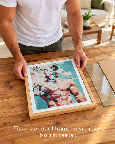 A man placing the Pale Weather paper art print with a white border into a standard wood frame, no mat needed
