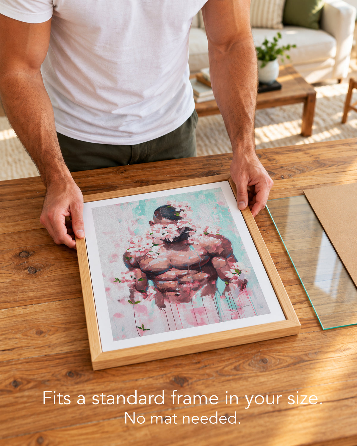 A man placing the Pink Static paper art print with a white border into a standard wood frame, no mat needed