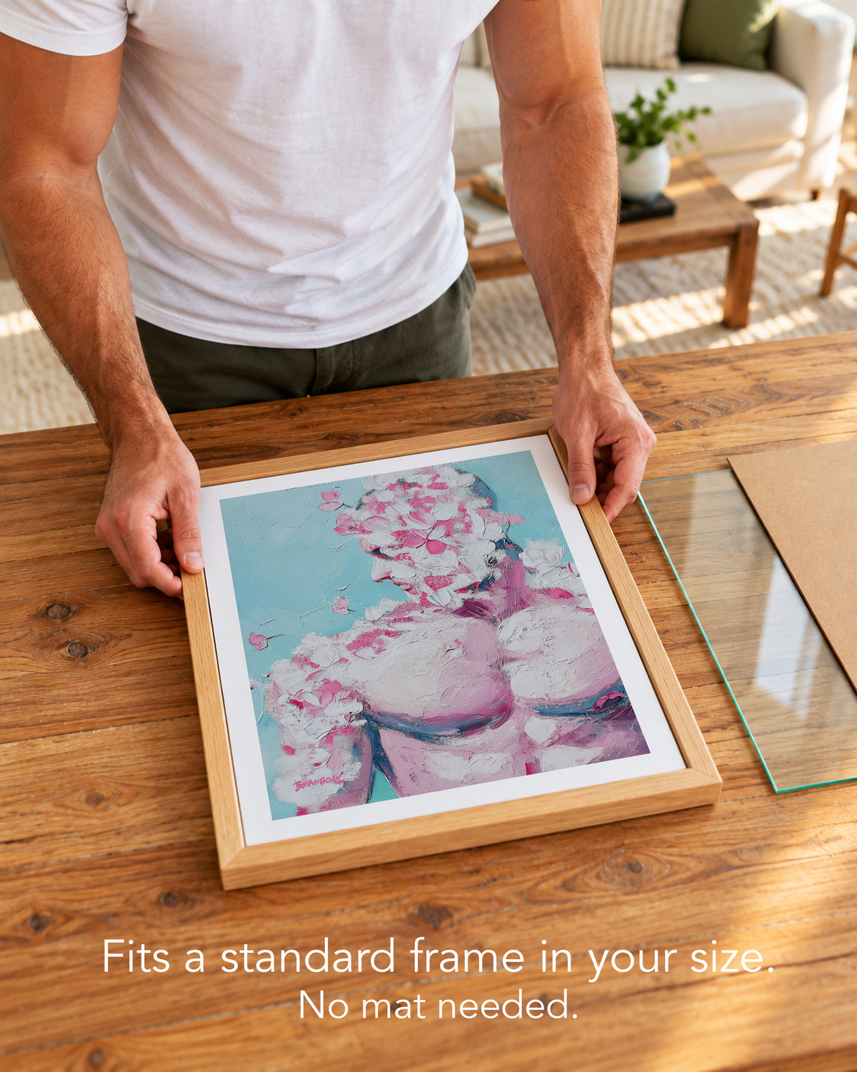 A man placing the Rose Plaster paper art print with a white border into a standard wood frame, no mat needed