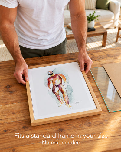 A man placing the Heavyweight paper art print with a white border into a standard wood frame, no mat needed