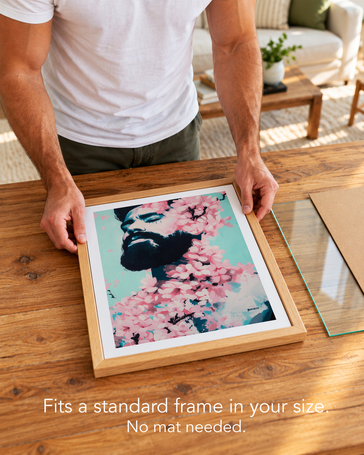 A man placing the Spring Exhale paper art print with a white border into a standard wood frame, no mat needed