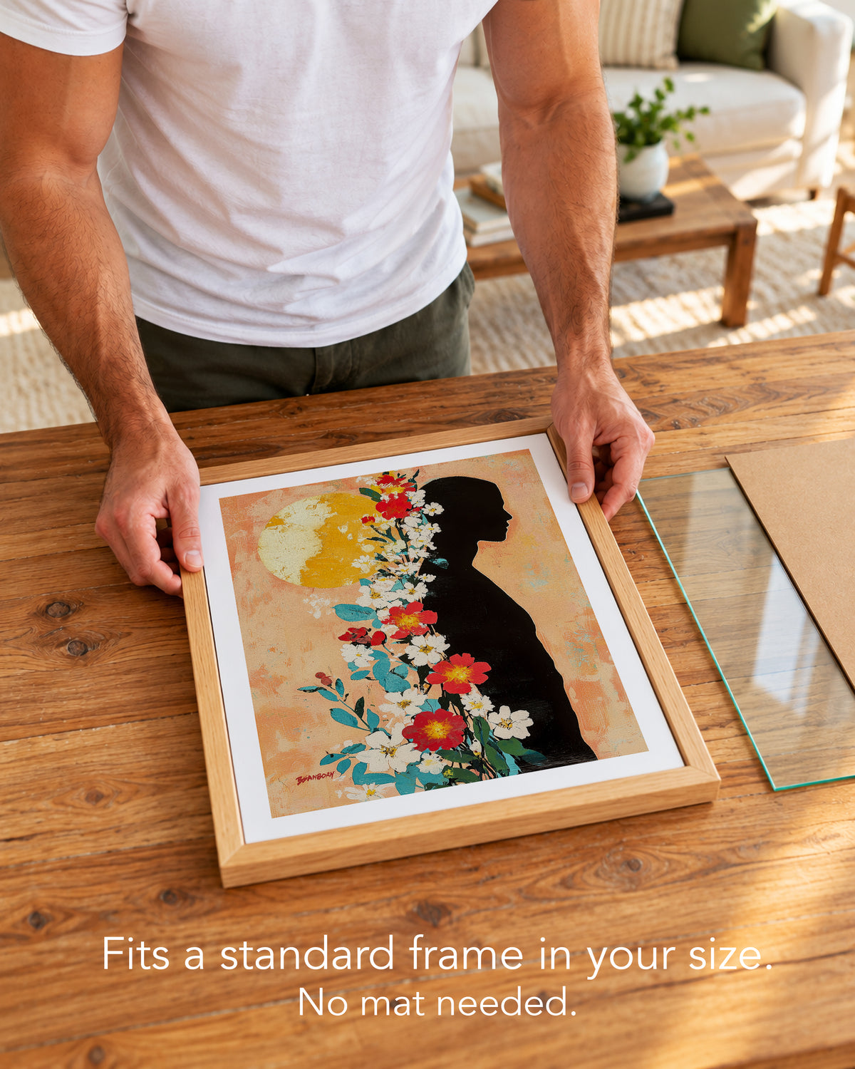 A man placing the Sun Keeper paper art print with a white border into a standard wood frame, no mat needed