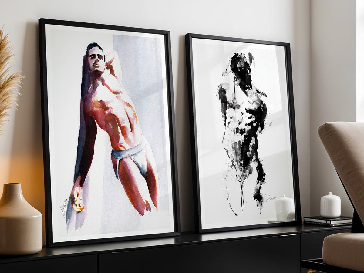 Two framed prints by Brenden Sanborn leaning on a dark console: a man in white briefs in watercolor and a black ink figure