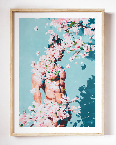 Under Branches art print by Brenden Sanborn, a figure half hidden behind blossoming branches with deep blue shadows, shown in a light wood frame