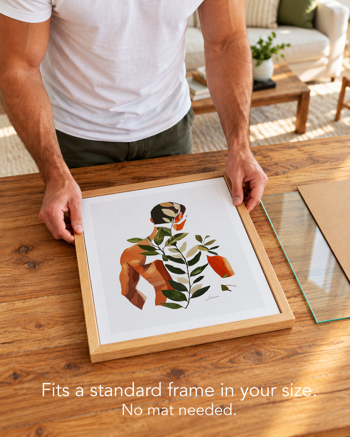 A man placing the Vine Memory paper art print with a white border into a standard wood frame, no mat needed
