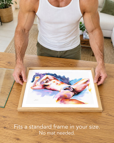 A man placing the Wide Awake paper art print with a white border into a standard wood frame, no mat needed