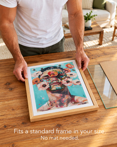 A man placing the Wild Mask paper art print with a white border into a standard wood frame, no mat needed